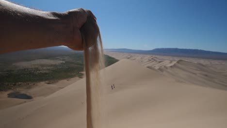 Sand-Fällt-In-Zeitlupe-Von-Der-Hand,-Wüste-Gobi,-Mongolei